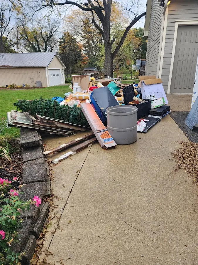 Dumpster being loaded with debris for 12 Yard Dumpster Rental in Grape Creek